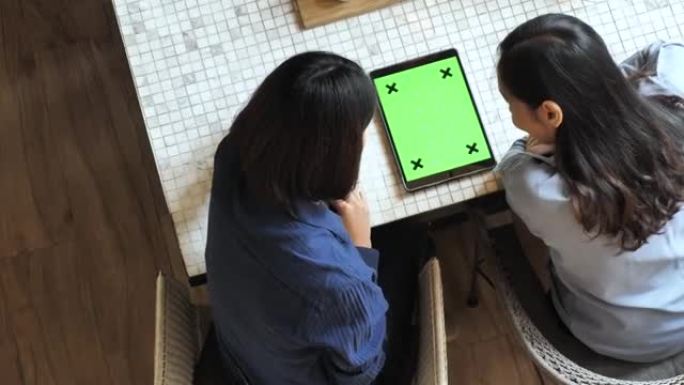 两人使用平板电脑绿屏，高角度视图