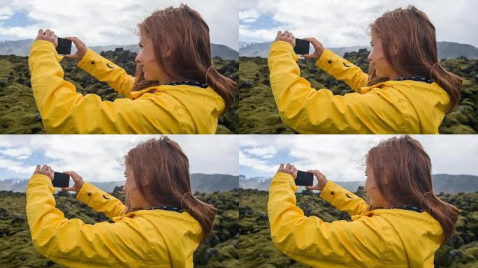 穿着黄色雨衣的游客在火山景观上拍摄苔藓覆盖