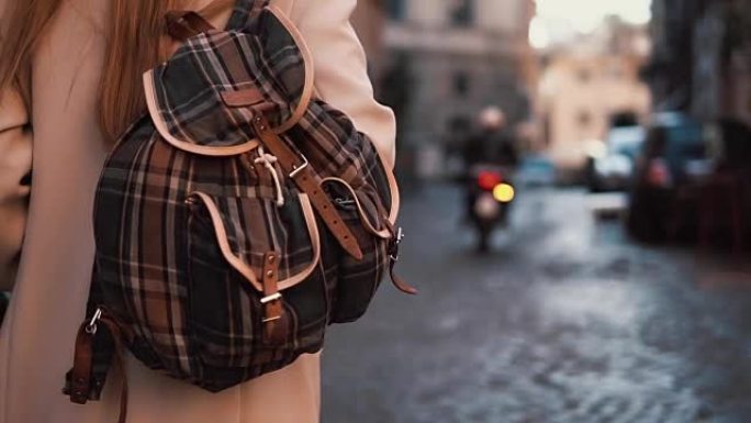 背着背包走在街上的年轻旅游女子的后景。漂亮女孩在欧洲度假