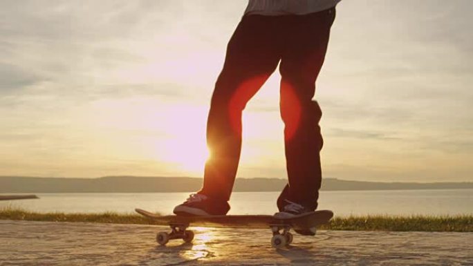 特写: 溜冰者将滑板抛向空中并在金色日落时跳上