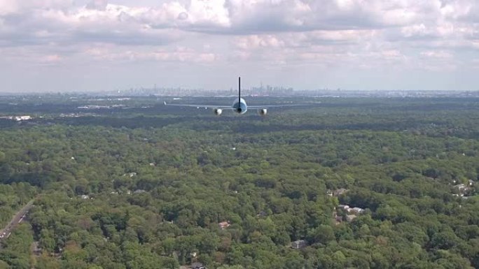 空中大型货运飞机飞越覆盖纽约郊区的森林