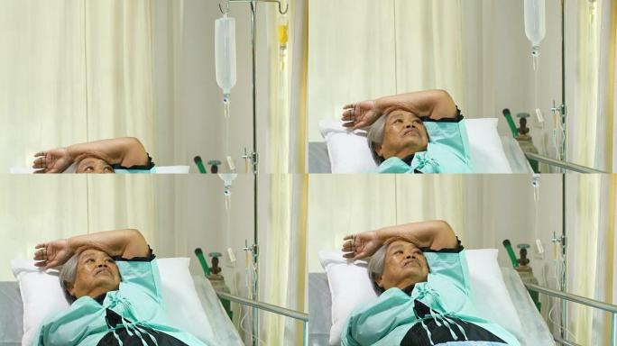 患有静脉滴注的高级妇女在医院病床上因疼痛和失眠而康复