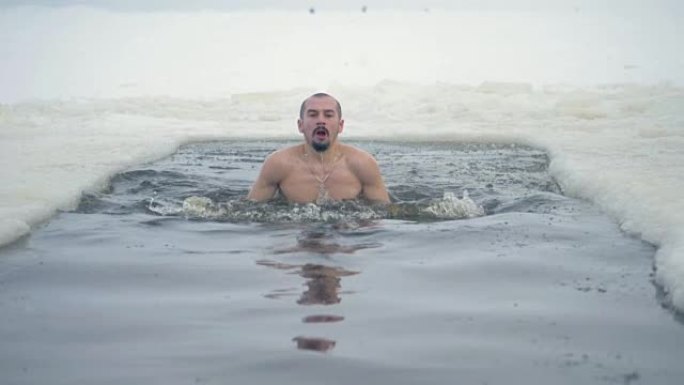一个人在冰洞里游泳，试图深呼吸。