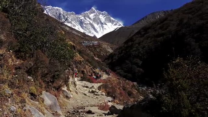 一群游客和搬运工在喜马拉雅山的小路上。慢动作镜头。4K, UHD