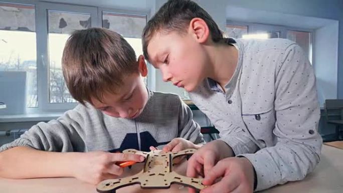 两个男孩正在完成他们的木制无人机模型