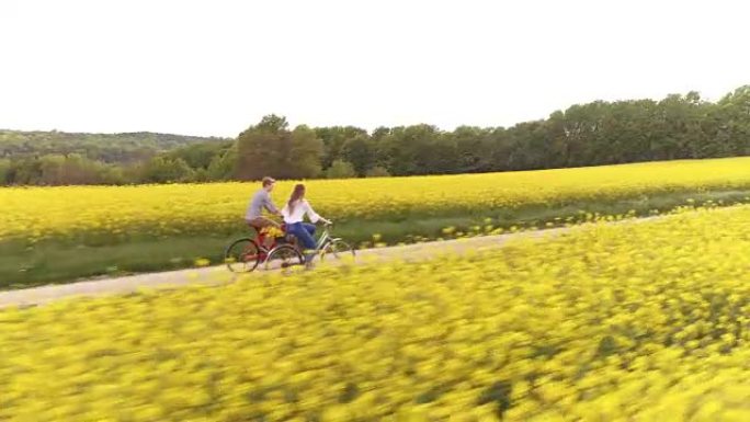 空中爱恋的夫妇在骑自行车时手牵手