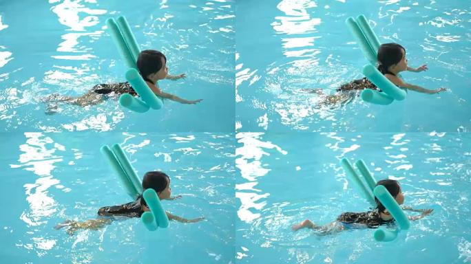 SLO MO蹒跚学步的女孩和面条一起游泳