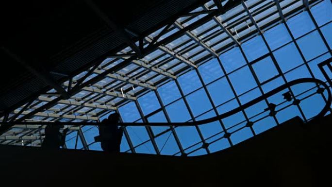 机场或公共场所的自动扶梯场景: 人们在楼梯上的剪影