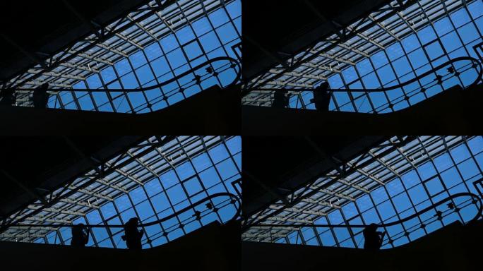 机场或公共场所的自动扶梯场景: 人们在楼梯上的剪影