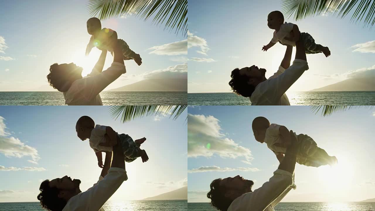 年轻的爸爸在日落时以慢动作举起婴儿