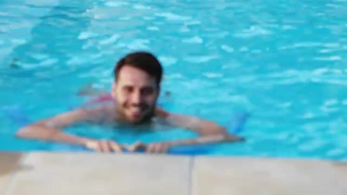 男子在游泳池里用充气管游泳