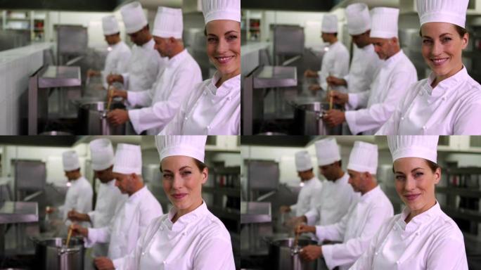 主厨在镜头前微笑，团队在她身后