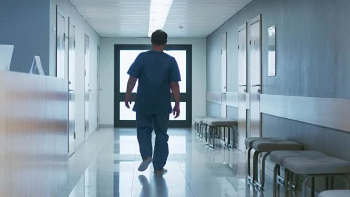 在医院里，老人在接待处问问题，然后沿着走廊走。清洁现代医疗设施。