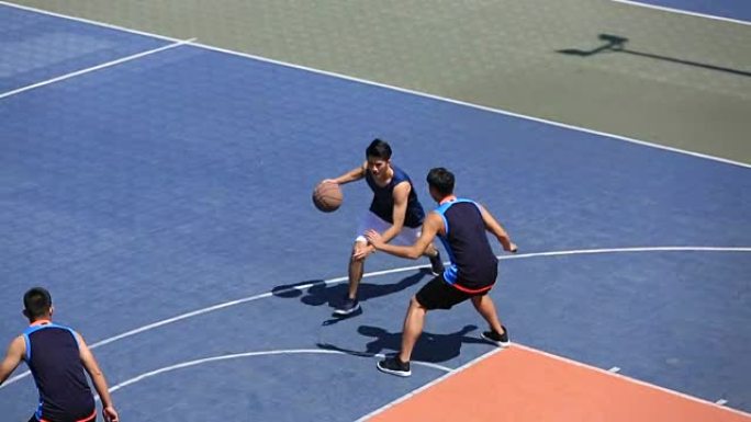 亚洲年轻人在室外球场打篮球