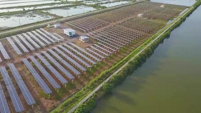 空中太阳能发电站或太阳能电池板在日落时分飞越东南亚当地道路和湖泊附近的拍摄和反射