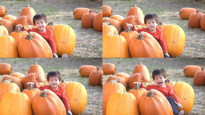 快乐的亚洲小男孩坐在大南瓜上