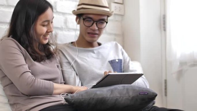 亚洲夫妇在平板电脑上听音乐