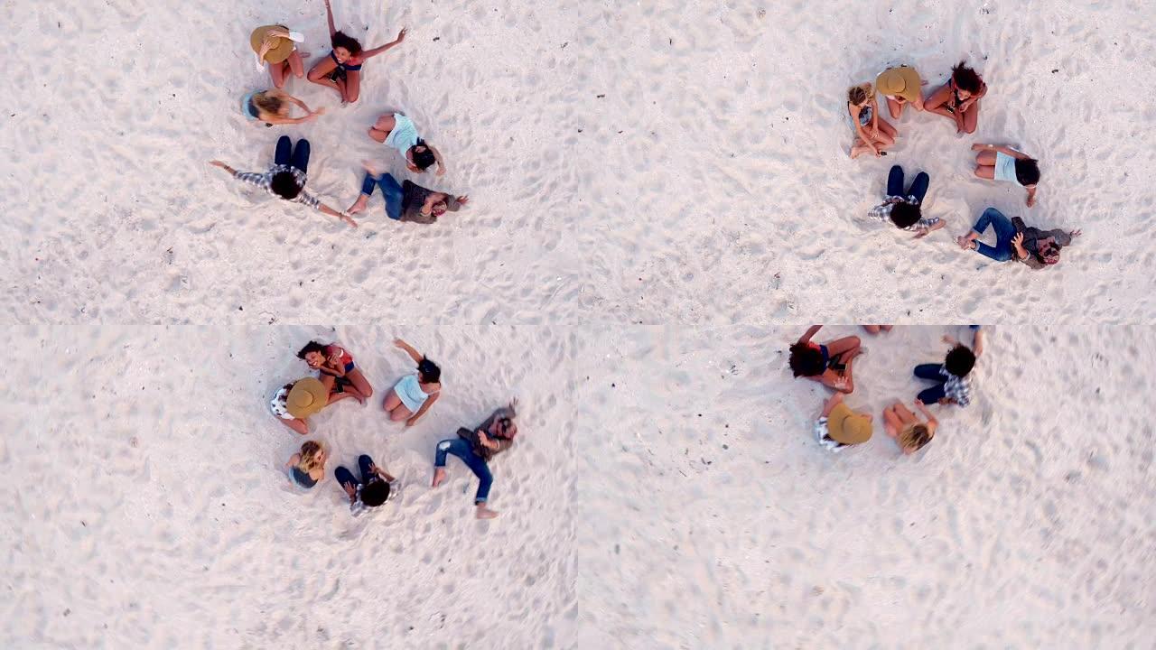 多种族的潮人朋友坐在沙滩上互相拥抱