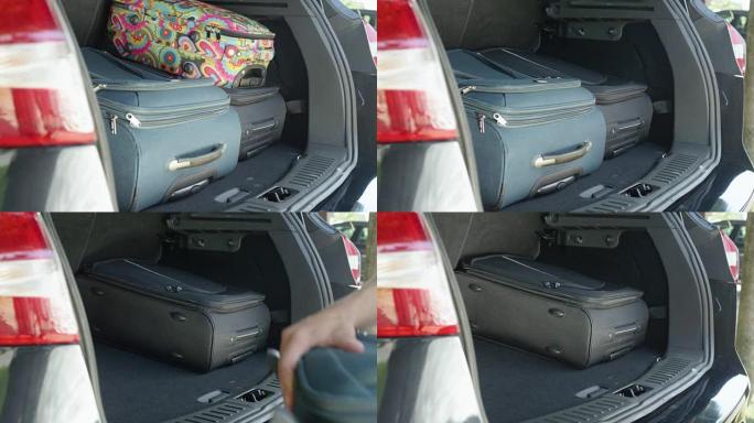 特写: 面目全非的人从现代黑色SUV卸下沉重的行李箱。