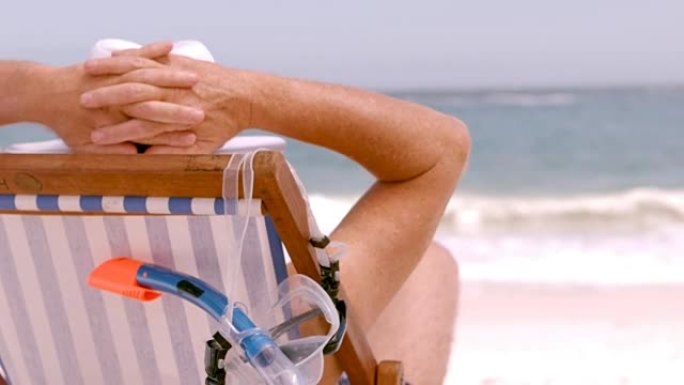 一位老人坐在沙滩椅上