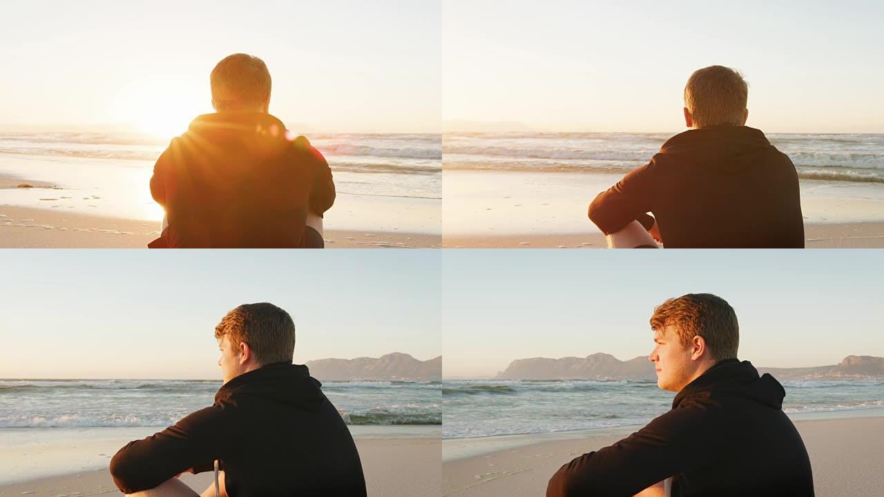 在海滩上看太阳升起的年轻人的后视图