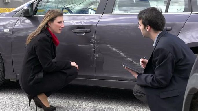 女人和保险代理人讨论汽车损坏