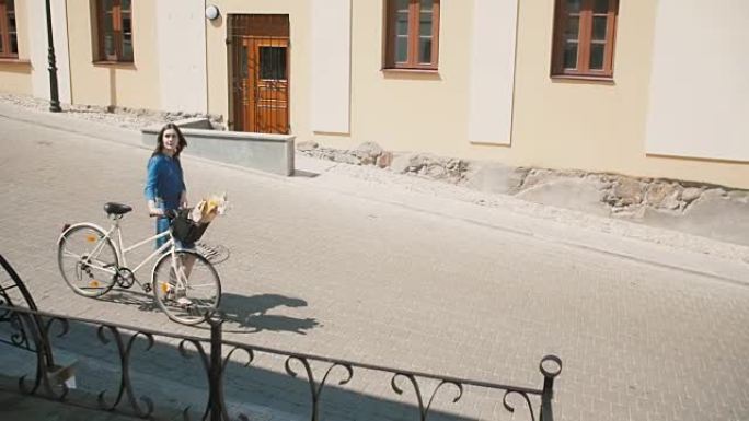 夏天，年轻女子走在老城区，带着一辆复古自行车，篮子里放着花，慢慢来