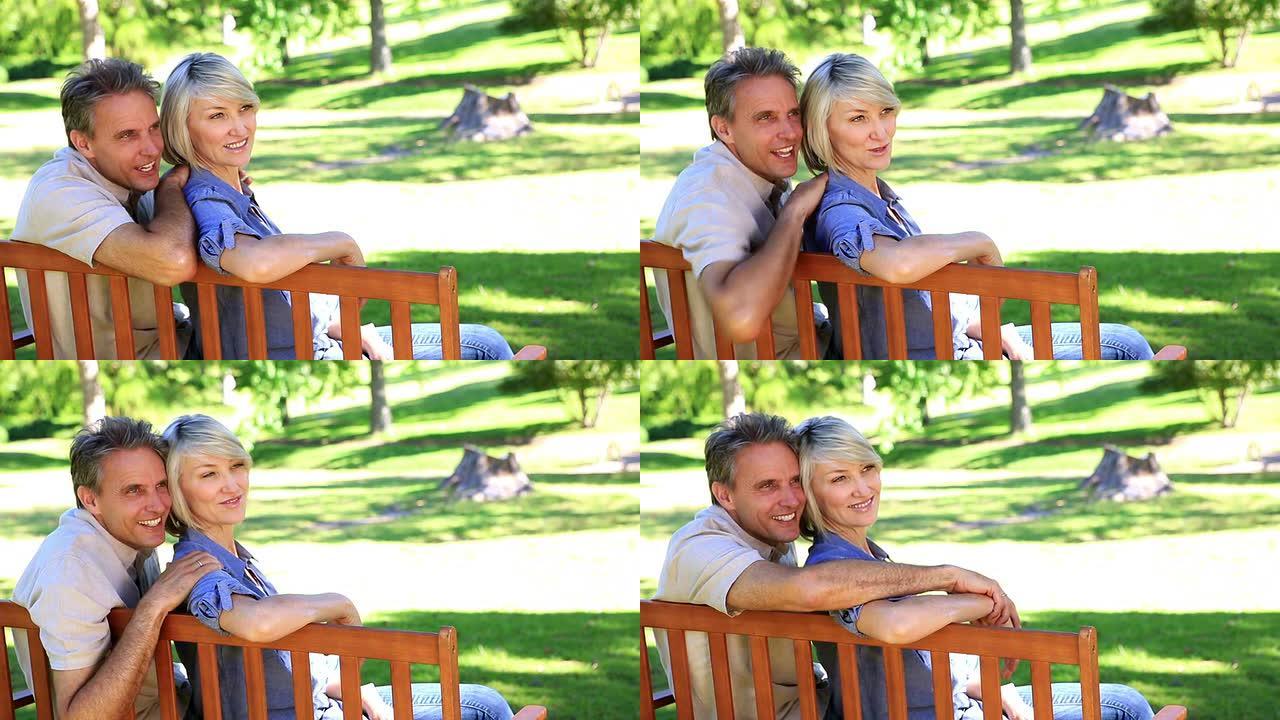 深情情侣坐在公园长椅上聊天