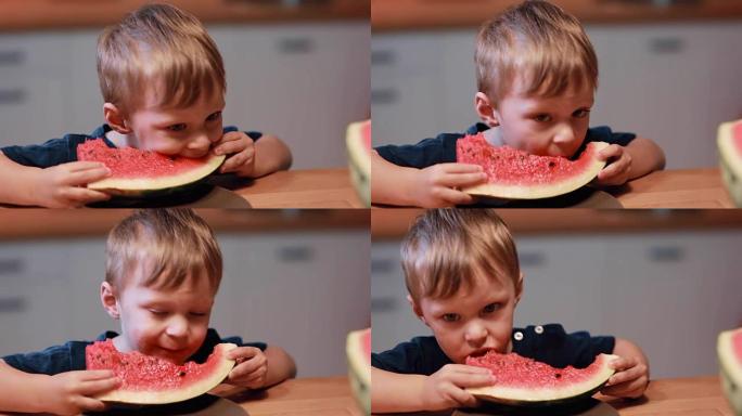 坐在厨房桌子旁的可爱小男孩的特写镜头。孩子抱着一块吃西瓜