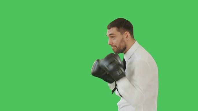 一个英俊的男人穿着衬衫和打领带，戴着拳击手套，然后在镜头前微笑。背景是绿色屏幕。