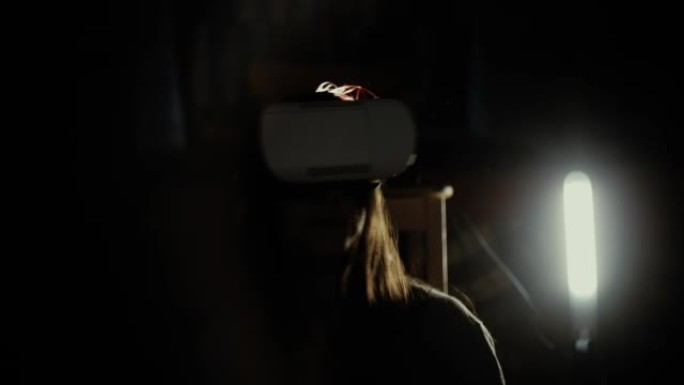 在聚光灯下使用VR头盔的女人
