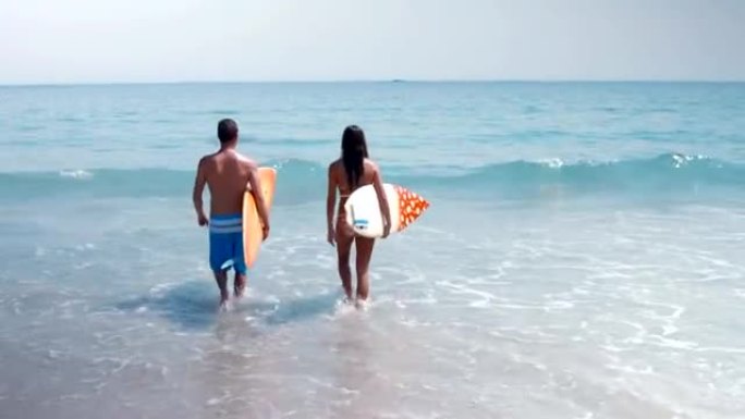 两个冲浪者用冲浪板在海上行走