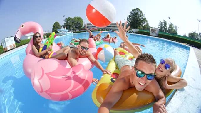 暑假自拍快乐的朋友躺在游泳池里有趣的彩色漂浮物上