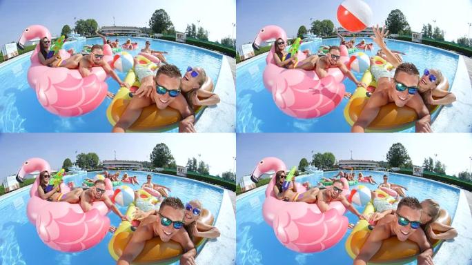 暑假自拍快乐的朋友躺在游泳池里有趣的彩色漂浮物上