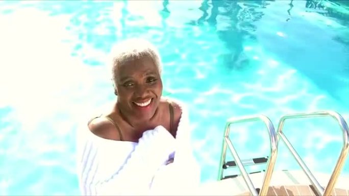 游泳池旁裹着毛巾的非裔美国高级妇女