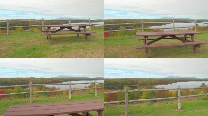 俯瞰湖泊和迷人多彩的森林的孤独野餐桌