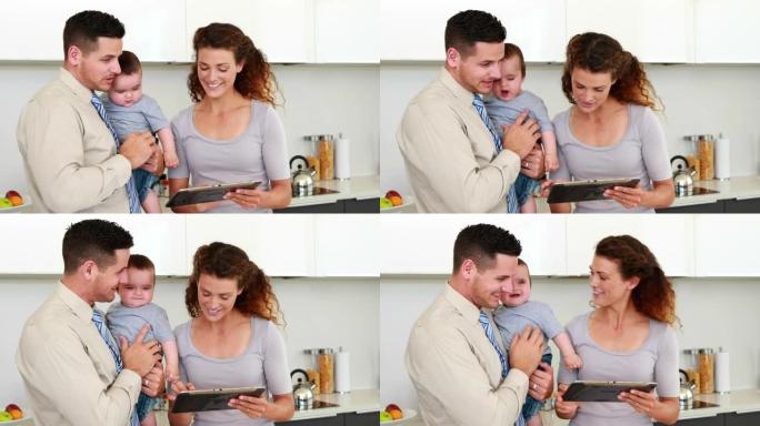 父母在父亲抱着婴儿时使用平板电脑