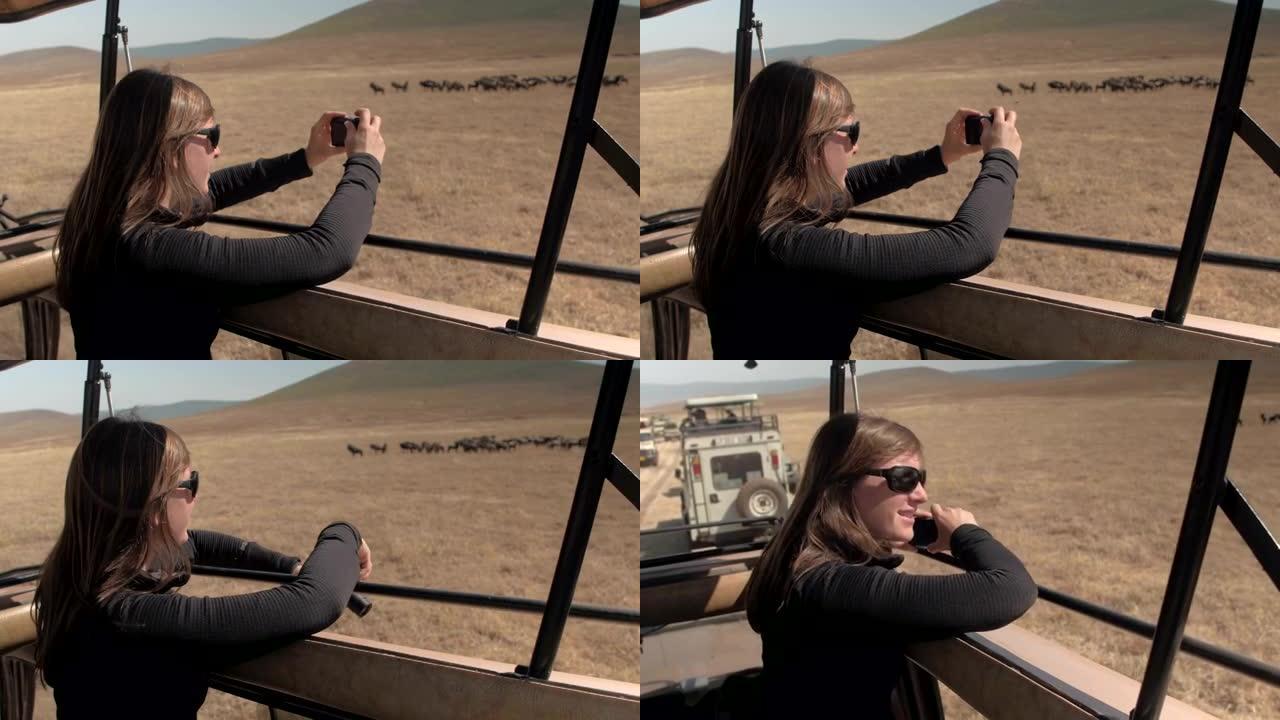 特写: 微笑的女孩在阳光明媚的非洲大草原上拍摄游戏动物的照片