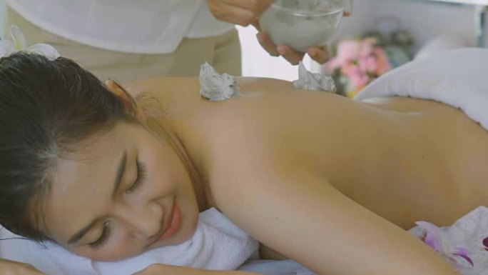 美丽的亚洲女性享受皮肤嫩肤治疗与身体面膜