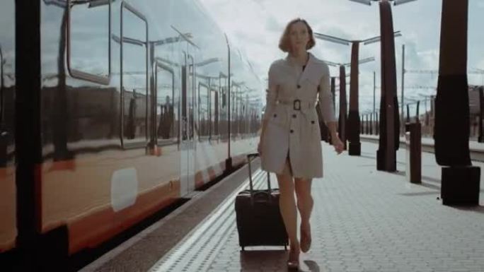自信的女人带着行李走在火车站上