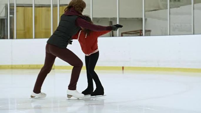 职业运动员与女孩一起练习花样滑冰