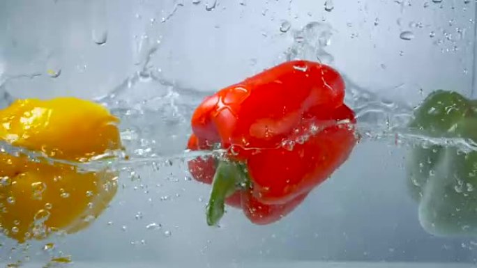 三个甜椒潜入清澈的水中。