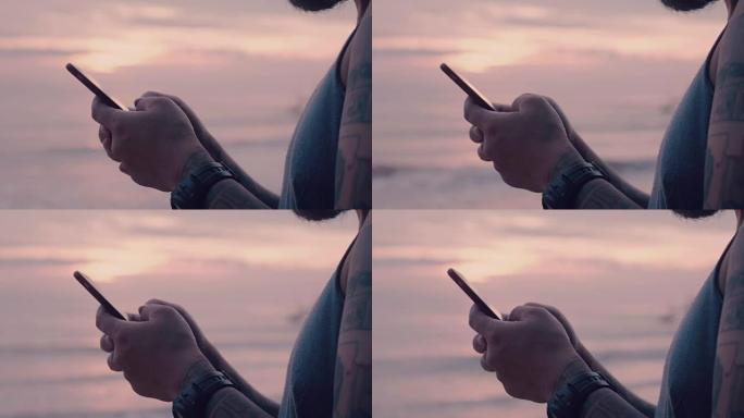 男子在日落时分在海上通过智能手机打字