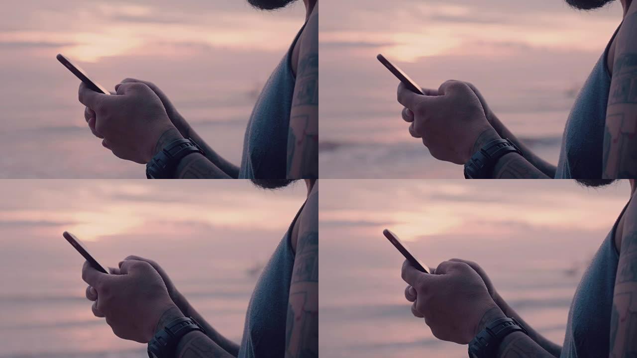 男子在日落时分在海上通过智能手机打字