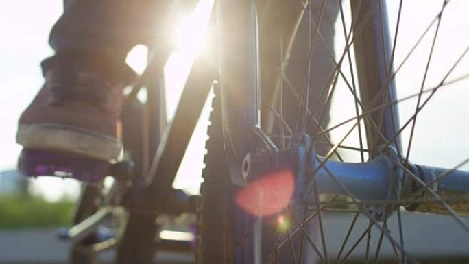 特写: bmx骑自行车的人在街上骑行的细节，阳光透过自行车车架