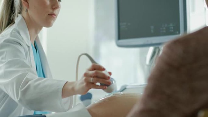 在医院，孕妇进行超声/超声筛查/扫描，产科医生在计算机屏幕上检查健康婴儿的照片。幸福的未来母亲。
