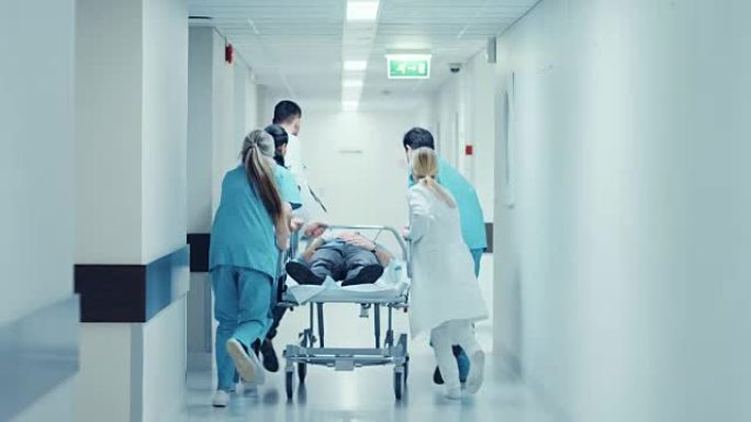 急诊科: 医生，护士和护理人员奔跑并将重伤员的轮床/担架推向手术室。明亮的现代医院，专业人员拯救生命