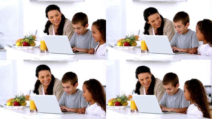 母亲带着孩子看着笔记本电脑