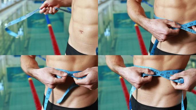 近距离的中间部分的一个赤膊健康游泳测量腰围