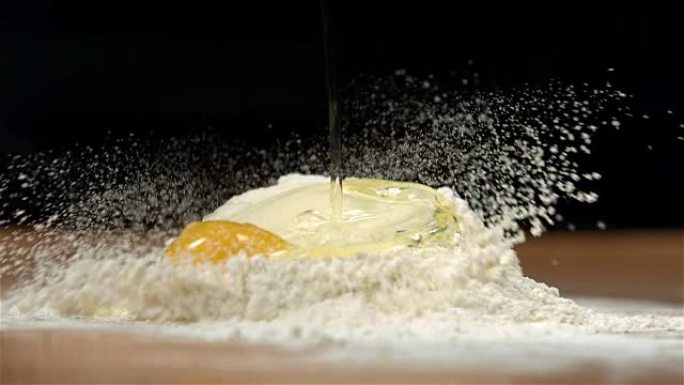 鸡蛋倒在桌子上的面粉上